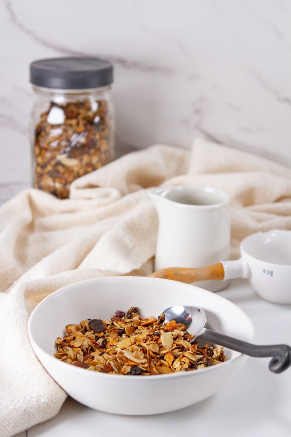 breakfast setting with cereal, milk, fruit, and a napkin.
