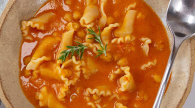 square crop looking down into a bowl of soup with a spoon on the right.