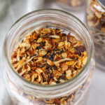 square crop looking into a glass mason jar filled with granola.