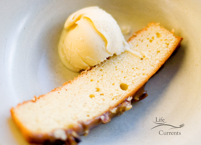 a scoop of ice cream served on a slice of cake. 