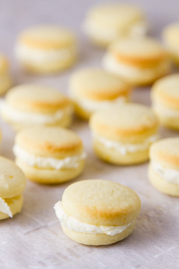 small bite sized sandwich cookies on a piece of white parchment paper