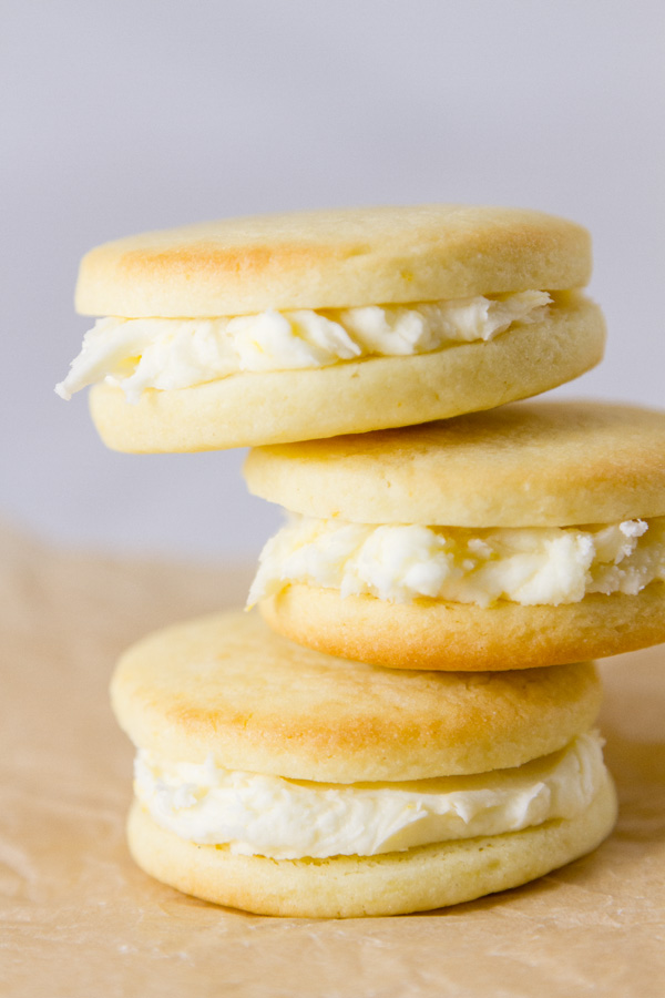 a stack of sandwich cookies on a piece of parchment paper