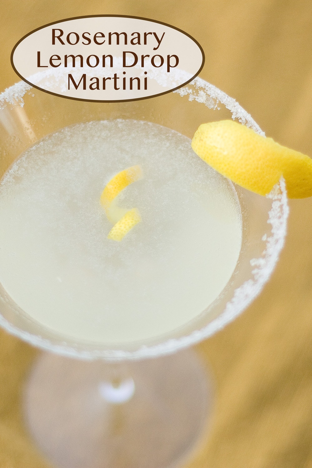 looking down into a martini glass filled with rosemary lemon drop martini.