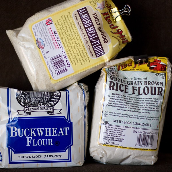 three bags of alternative flours on a dark background.