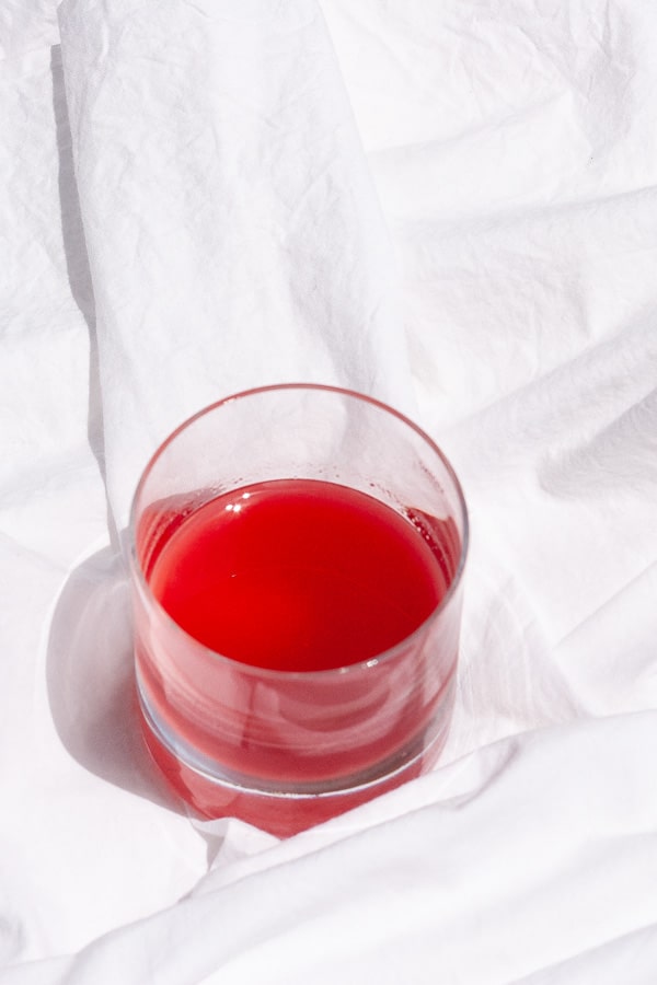 looking down on a glass of red syrup.