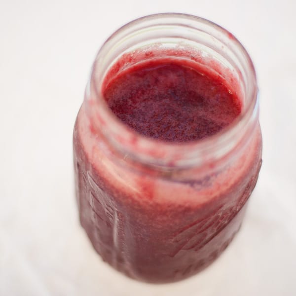looking down into a mason jar filled with red jam.