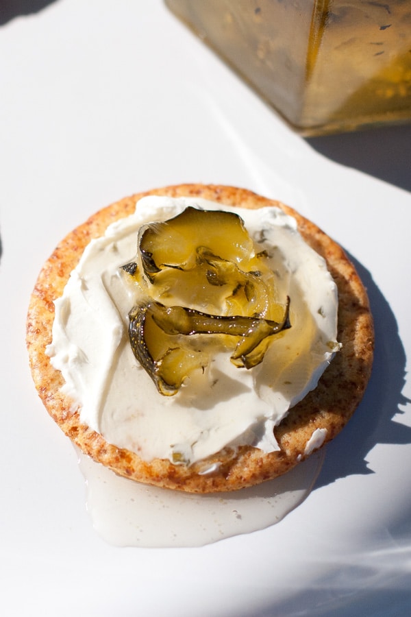 a cracker topped with cream cheese and jam.