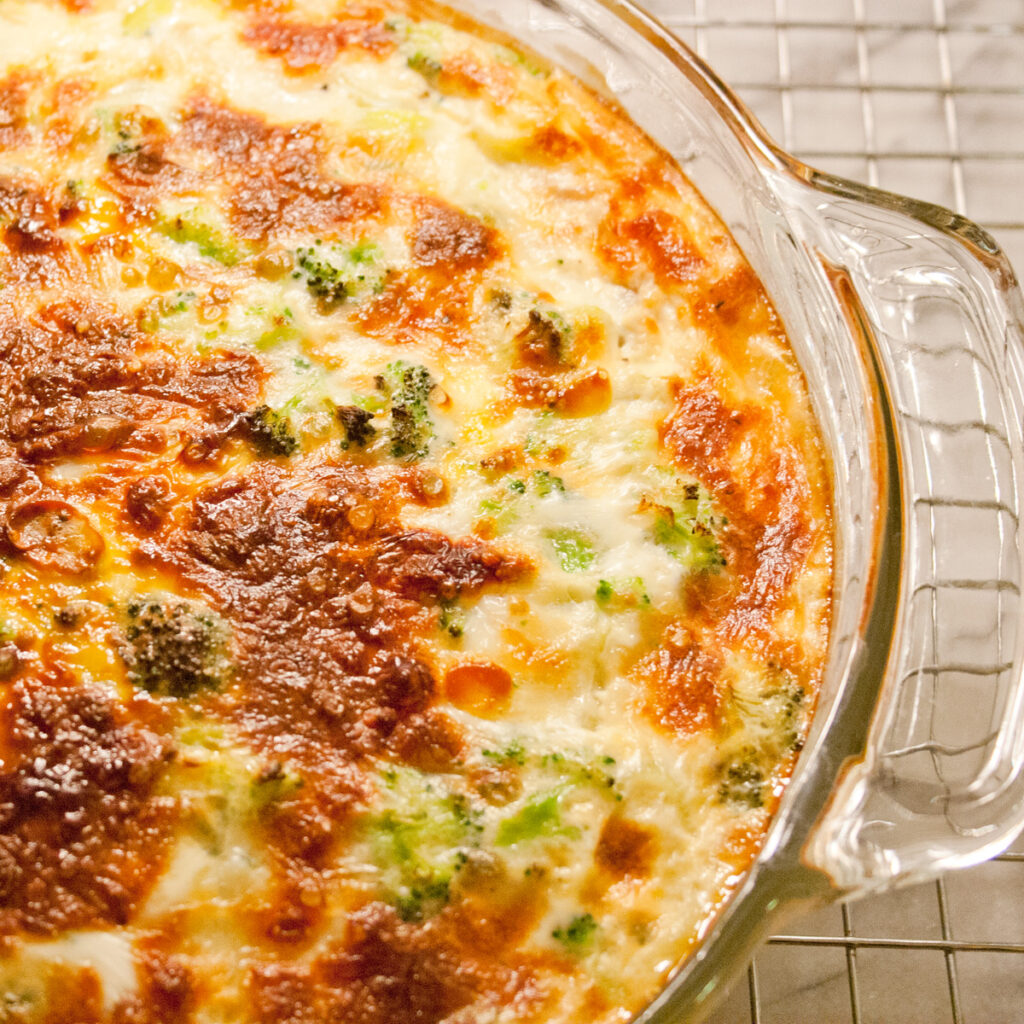 Broccoli Leek Mozzarella crustless quiche in a glass pan on a cooling rack.