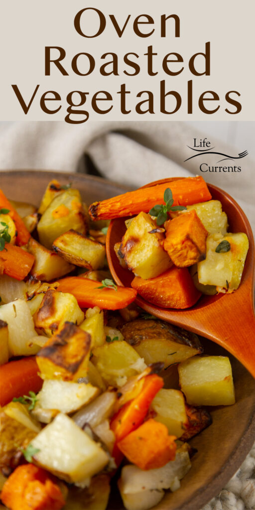 close up on oven roasted vegetables being served with a wooden spoon.