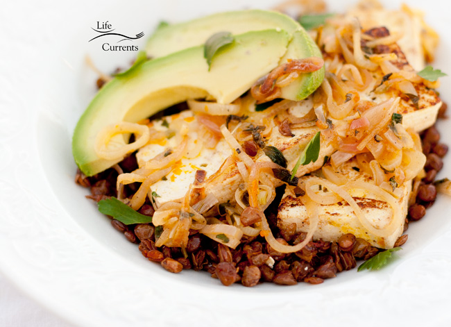 Orange-Shallot Tofu with Avocado Served on a Bed of Roasted Lentils - with avocados, tofu, shallots, all over chipotle lentils in a bowl