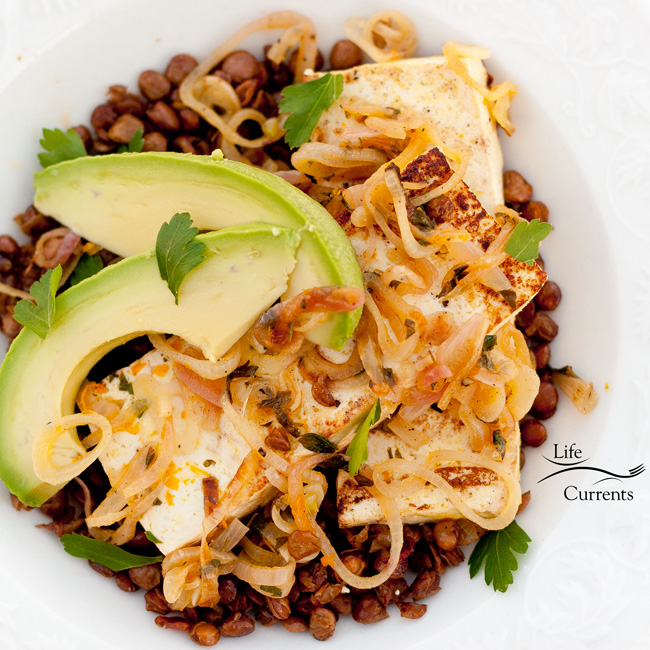 Orange-Shallot Tofu with Avocado Served on a Bed of Roasted Lentils a square photo