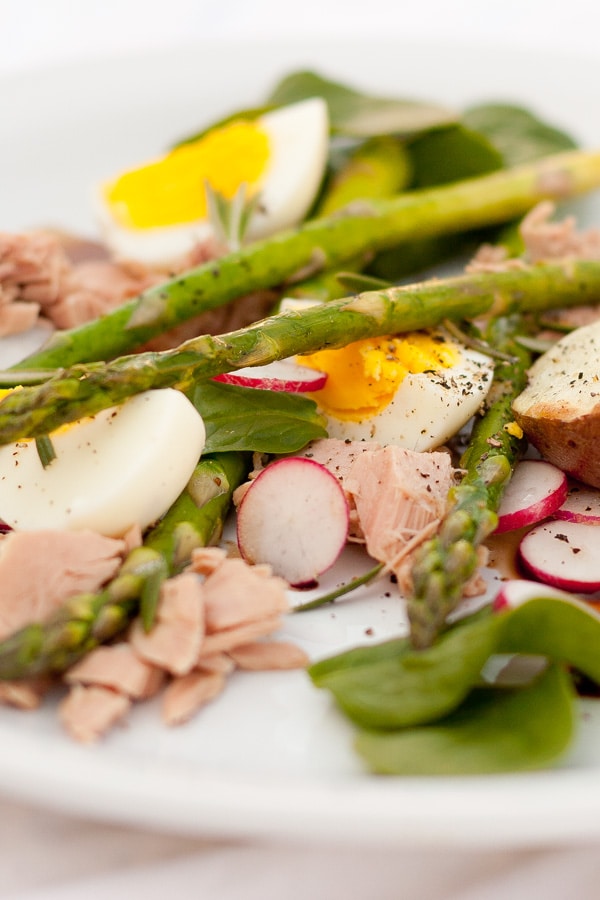 a white plate filled with a spring salad.