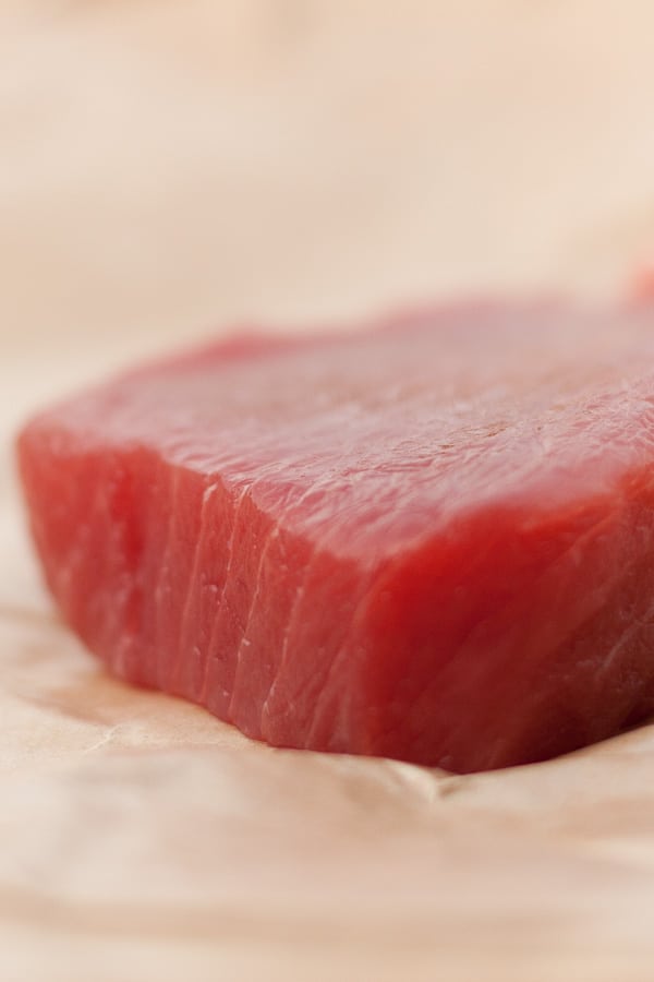 a piece of raw albacore tuna on parchment paper.