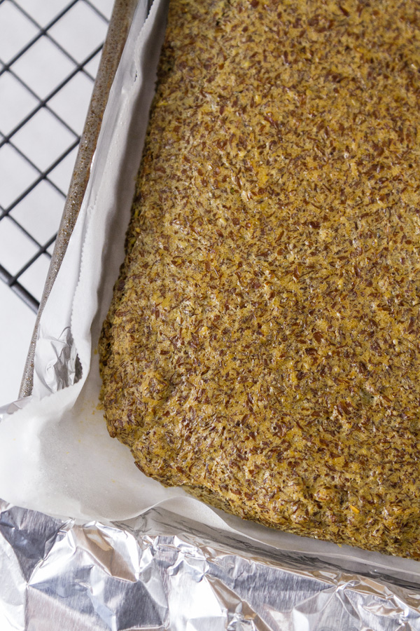 Gluten-Free Baking & Baked Goods: Gluten Free Flax Seed Bread is easy to make, high protein, low carb, and delicious Flax Seed Bread in the tray just after baking with parchment paper lining and aluminum foil in the tray all on a cooling rack