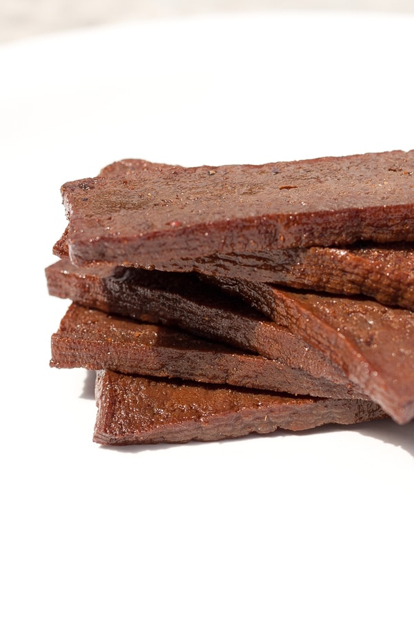 pieces of marinated and cooked tofu that are stacked on top of each other.