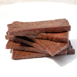 pieces of marinated and cooked tofu stacked on top of each other.