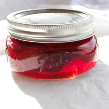 a small mason jar with strawberry jam in it.
