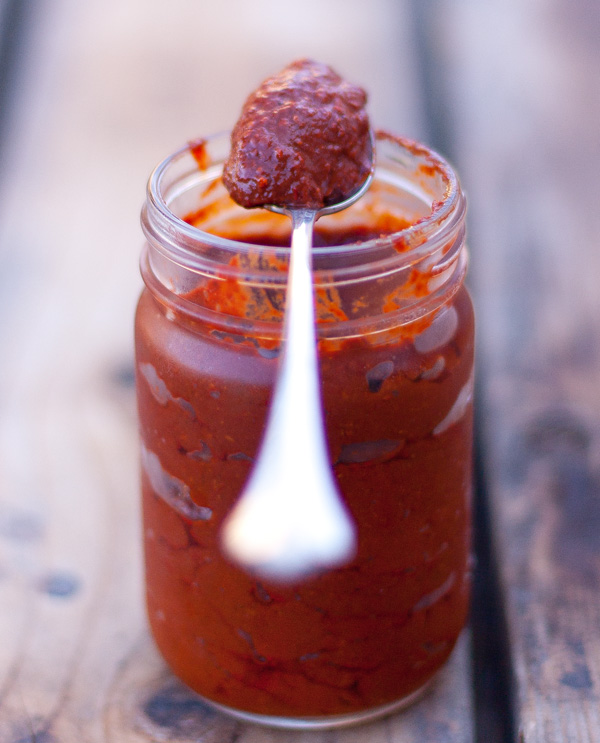 a jar of spicy paste with a spoonful on top
