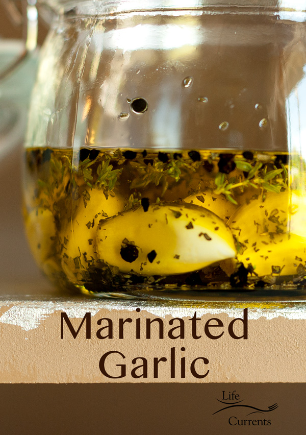 A side view of the Herb & Spice Marinated Garlic in a glass jar on the edge of a table
