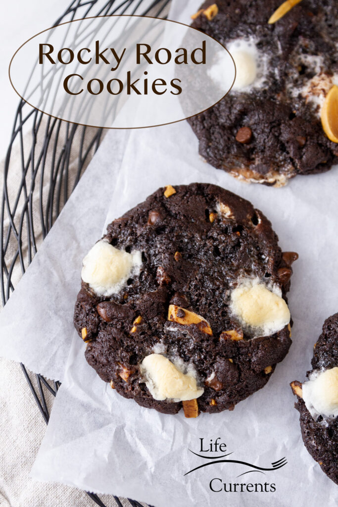 Chocolate rocky road cookies on parchment paper on a wire serving platter, title in upper left.