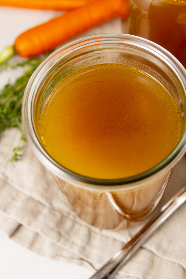 looking down into a large jar filled with homemade broth