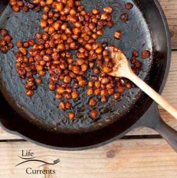 square crop of honey roasted garbanzo beans in a cast iron skillet.