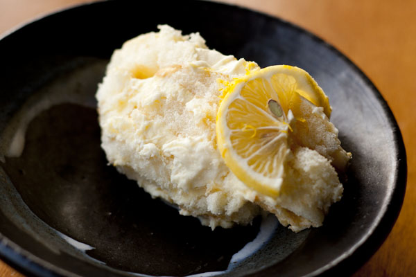 a serving of lemon tiramisu on a black plate