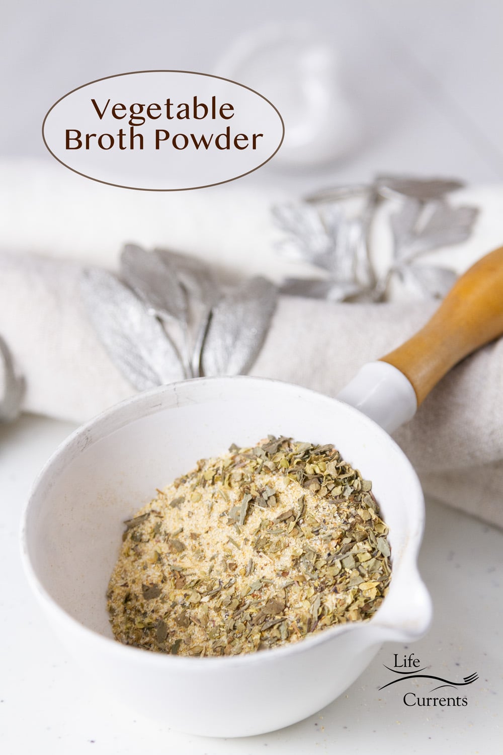 a small measuring cup filled with Vegetable Broth Powder next to a towel, and the title "Vegetable Broth Powder" in the upper left.