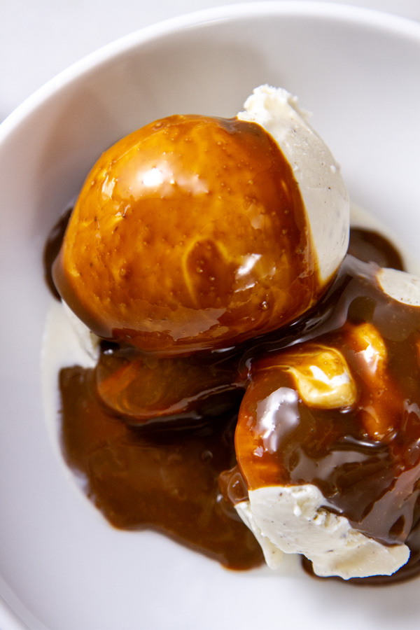 coffee sauce over vanilla ice cream in a white bowl.