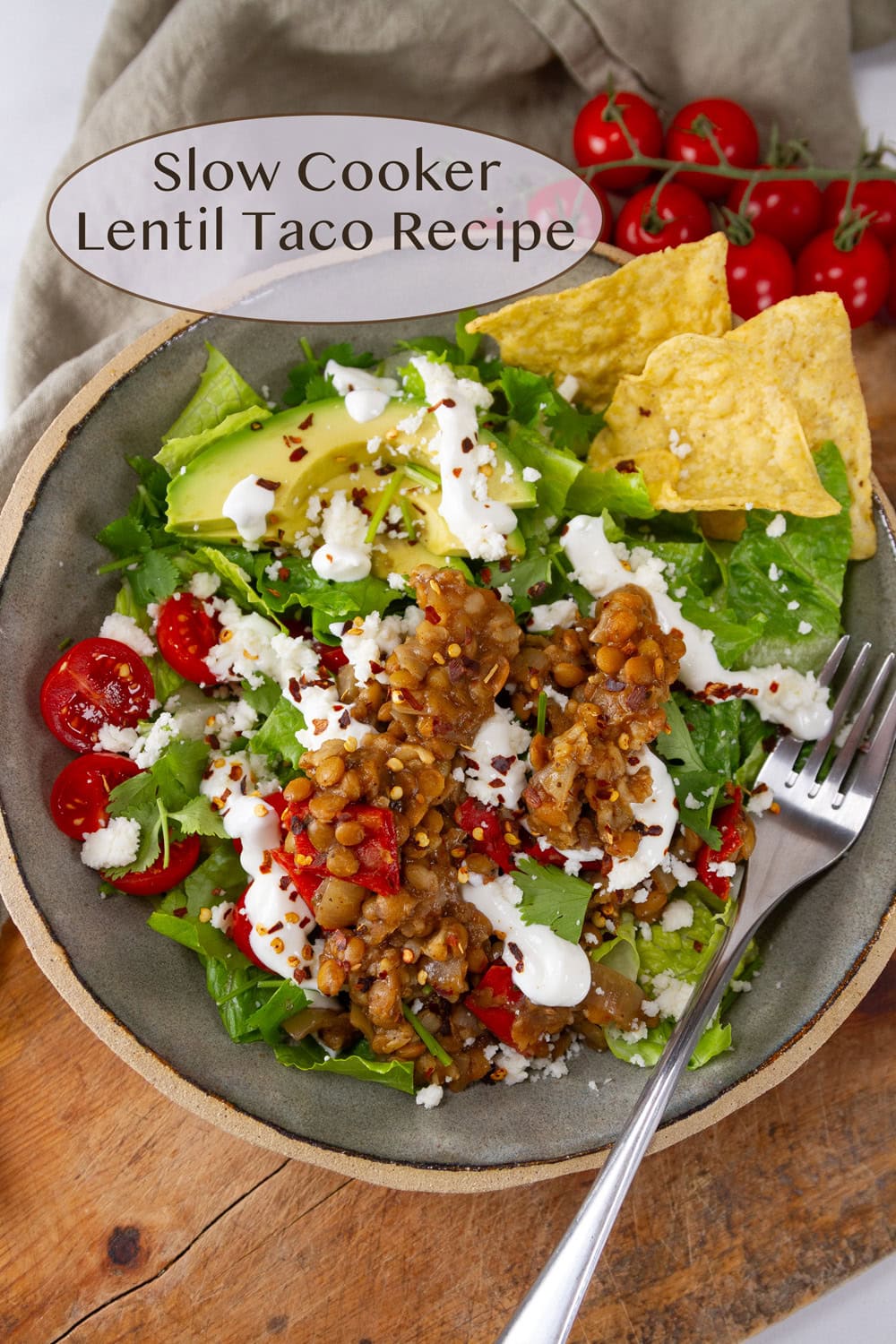 a bowl of lentil taco salad with lettuce, tomatoes, avocado, and tortilla chips.