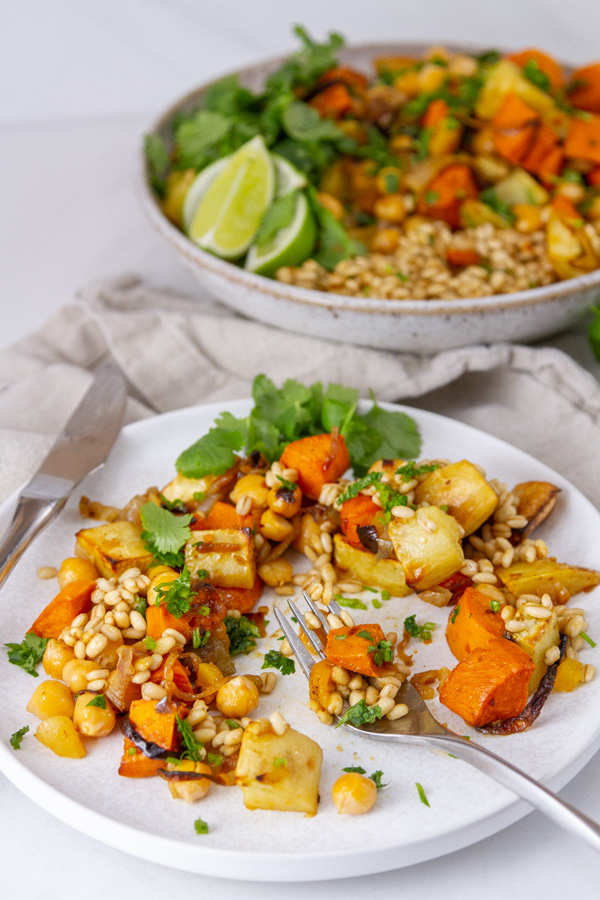 a plate full of veggies and grains in from of the serving bowl.