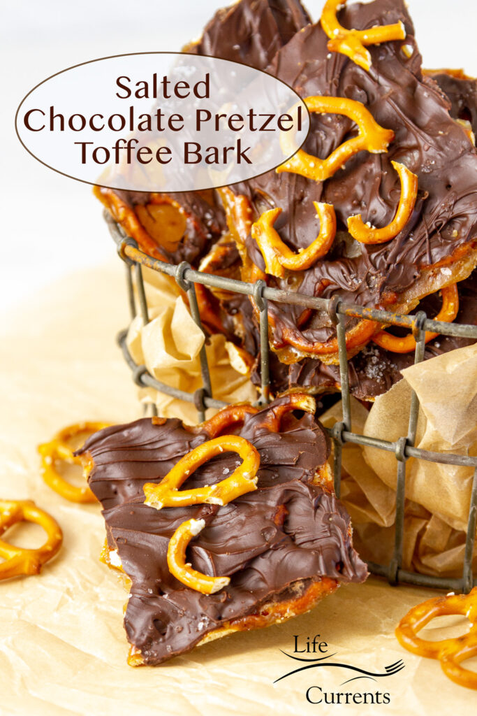 pieces of Salted Chocolate Pretzel Toffee Bark in a wire container with one piece in front and some broken pretzels around.