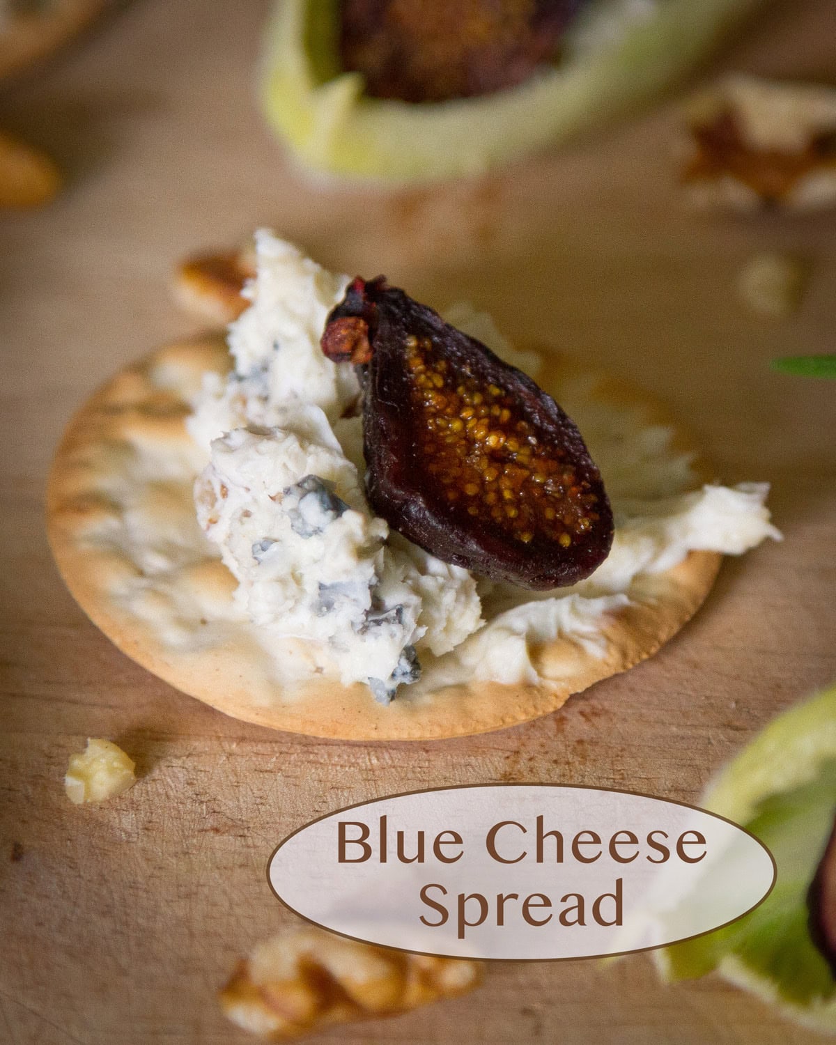 Blue Cheese Spread on water crackers with figs on a wooden serving board.