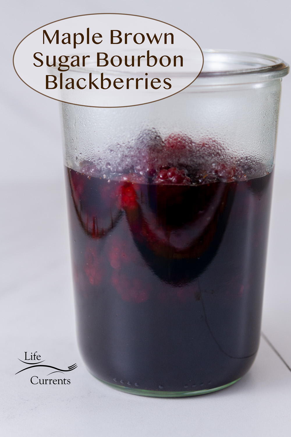 a glass jar filled with blackberries and syrup, title on top: Maple Brown Sugar Bourbon Blackberries .