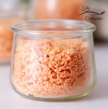 a small glass jar with pink salt inside.