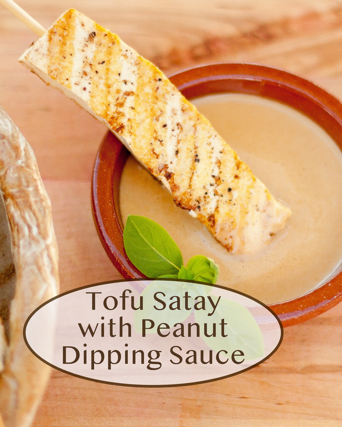tofu skewers on the left in a bowl and one on the right in a small bowl of peanut dipping sauce.