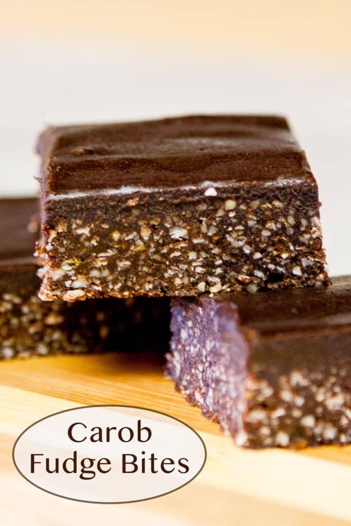 Carob fudge Bites stacked on a wooden board.
