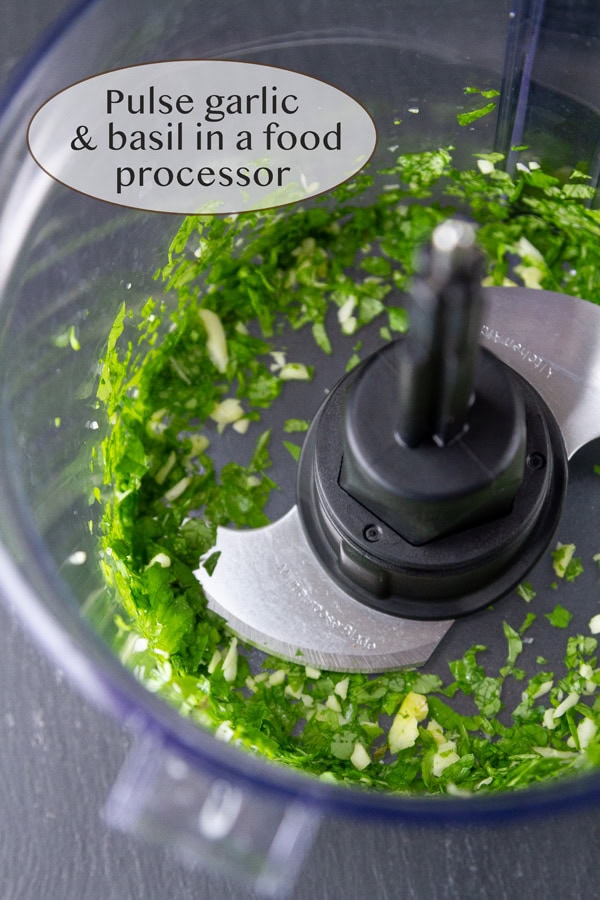 pureeing garlic and basil in a food processor.
