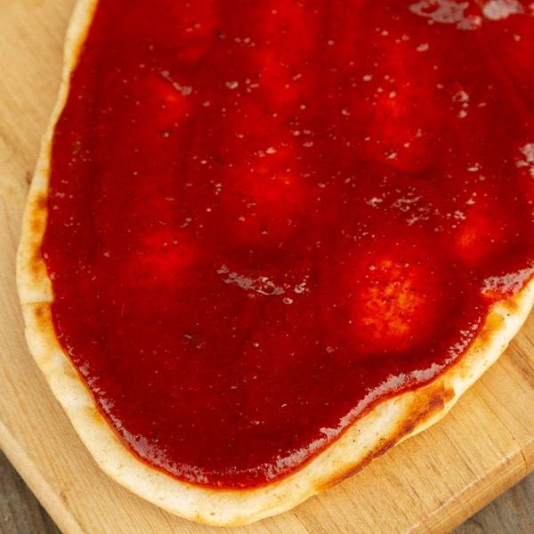 flatbread pizza with enchilada sauce on top.