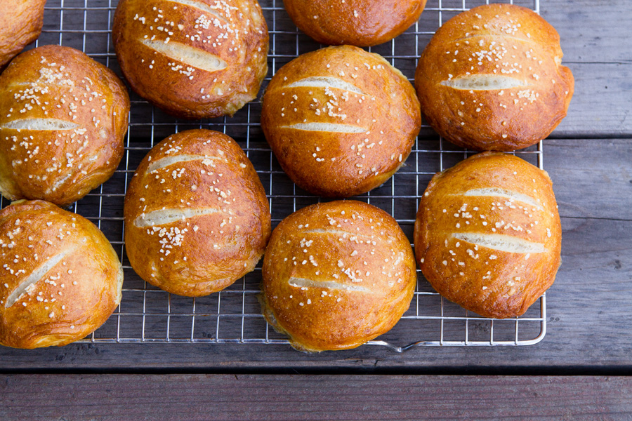horizontal crop of pretzel rolls on a wire rack.