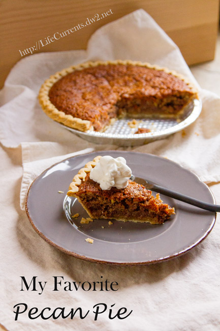 My Favorite Pecan Pie on a grey plate with the rest of the pie in the background.