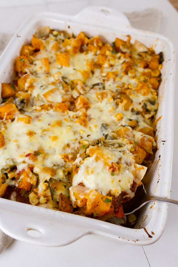 Mexican casserole in a pan with a serving beging taken out