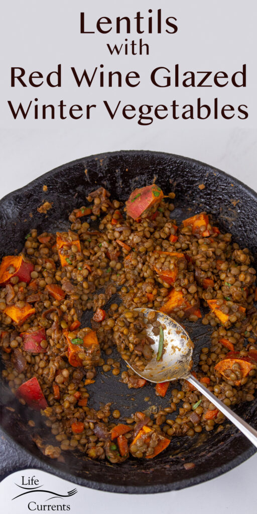 looking down into a cast iron skillet with lentils and sweet potatoes and a spoon, title on top of image: Lentils with wine glazed winter vegetables.