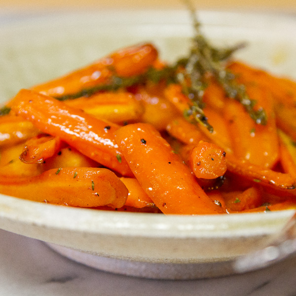 close up on roasted cooked carrots on a serving plate 