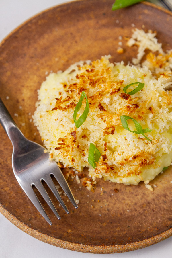 a serving of mashed potatoes on a brown plate.