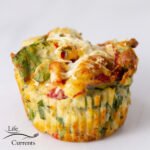 square crop of savory spinach muffin topped with cheese