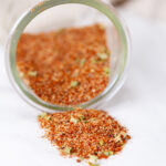square crop of a glass jar filled with spice mix that's been tipped over.