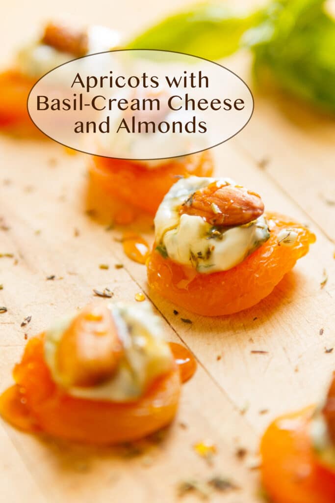 Apricot appetizer with cheese and almonds on a wooden cutting board.