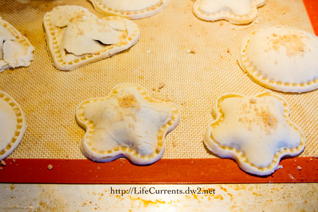 pie dough with sugar on it cut into shapes.