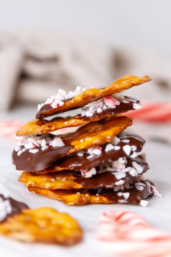 a stack of peppermint pretzels with candy canes around.